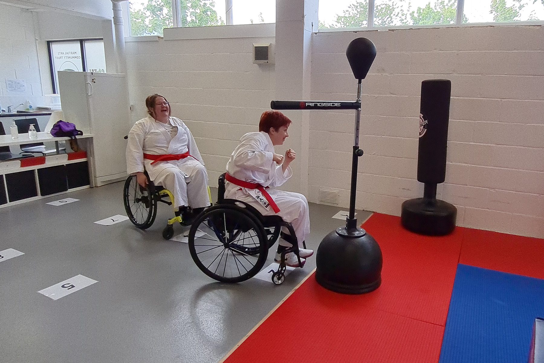 Photo of girl in a wheelchair punching a punchbag