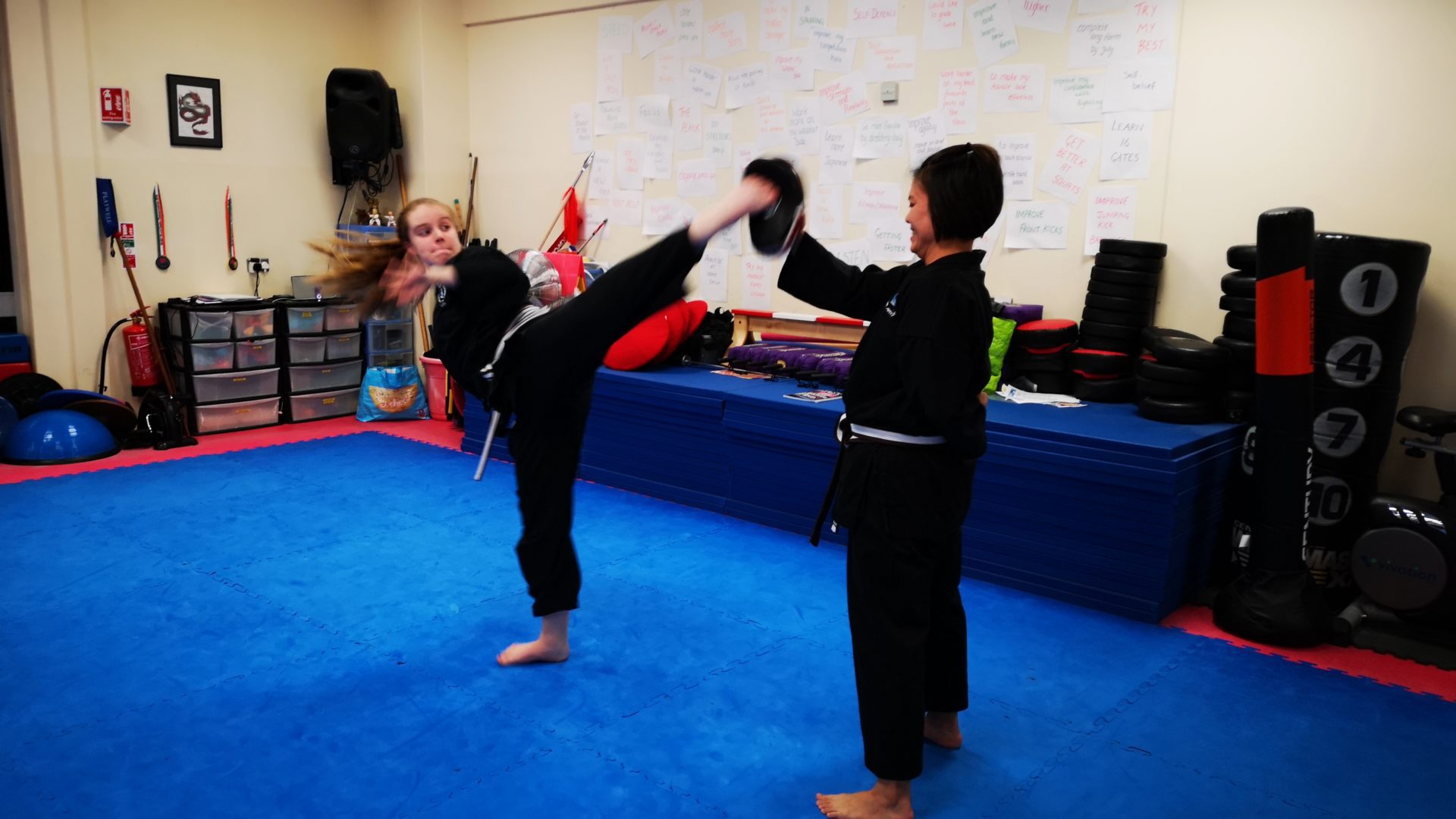 photo of two adults practicing kung fu kicks